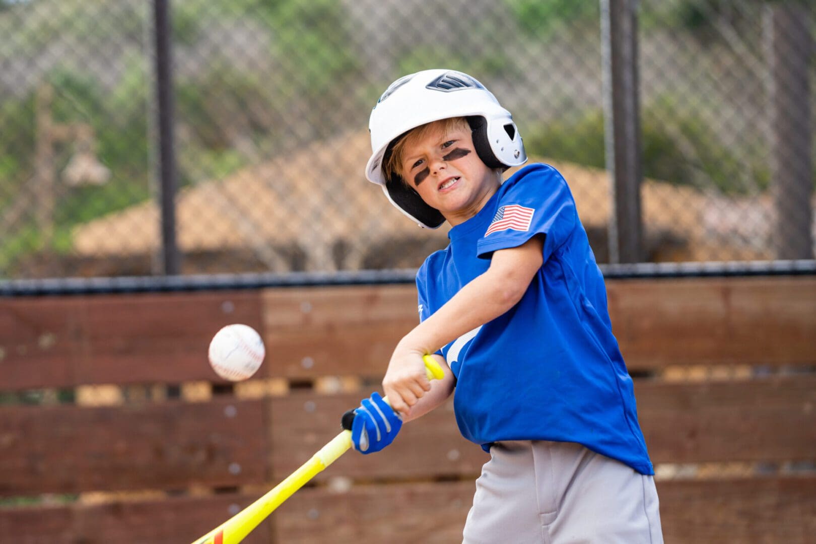 Boy swinging baseball bat at pitch.