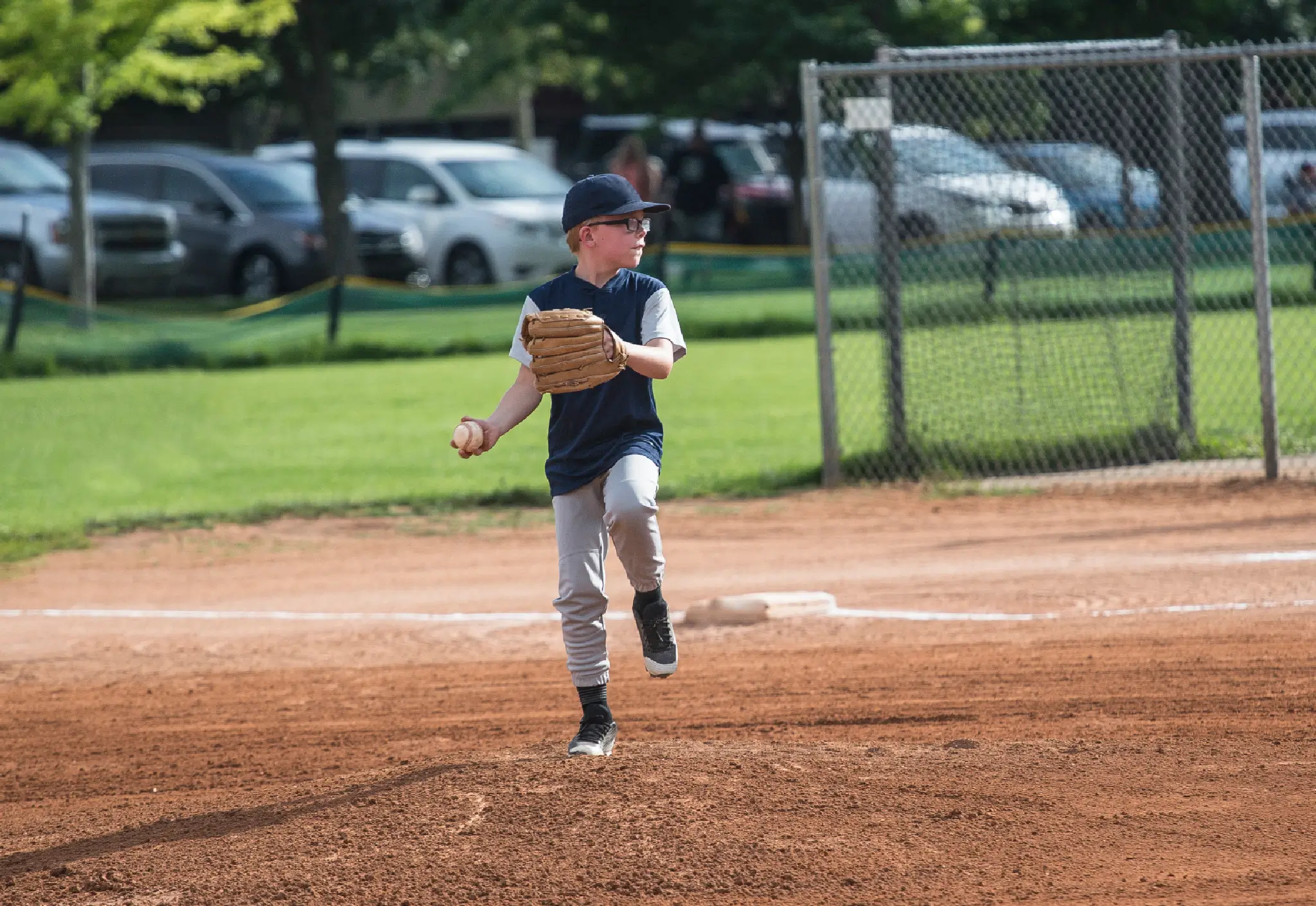 Young boy pitching in baseball game.