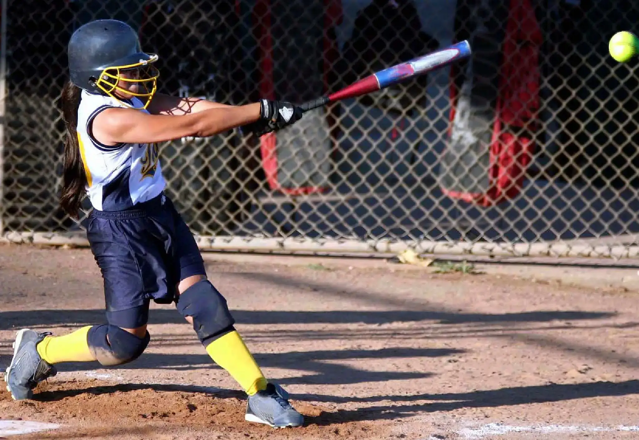 Softball player hitting a pitched ball.