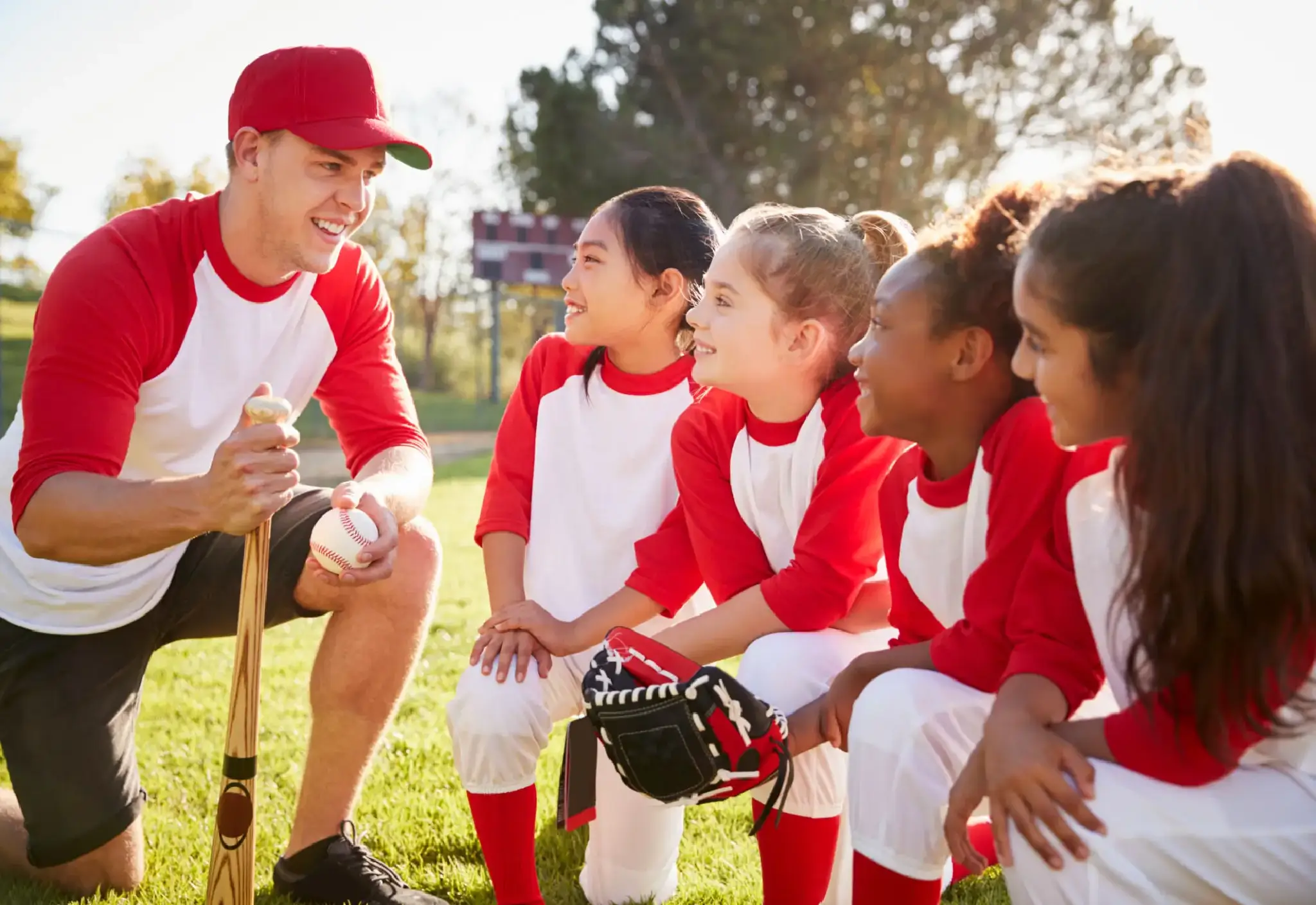 Coach talking to young baseball team.