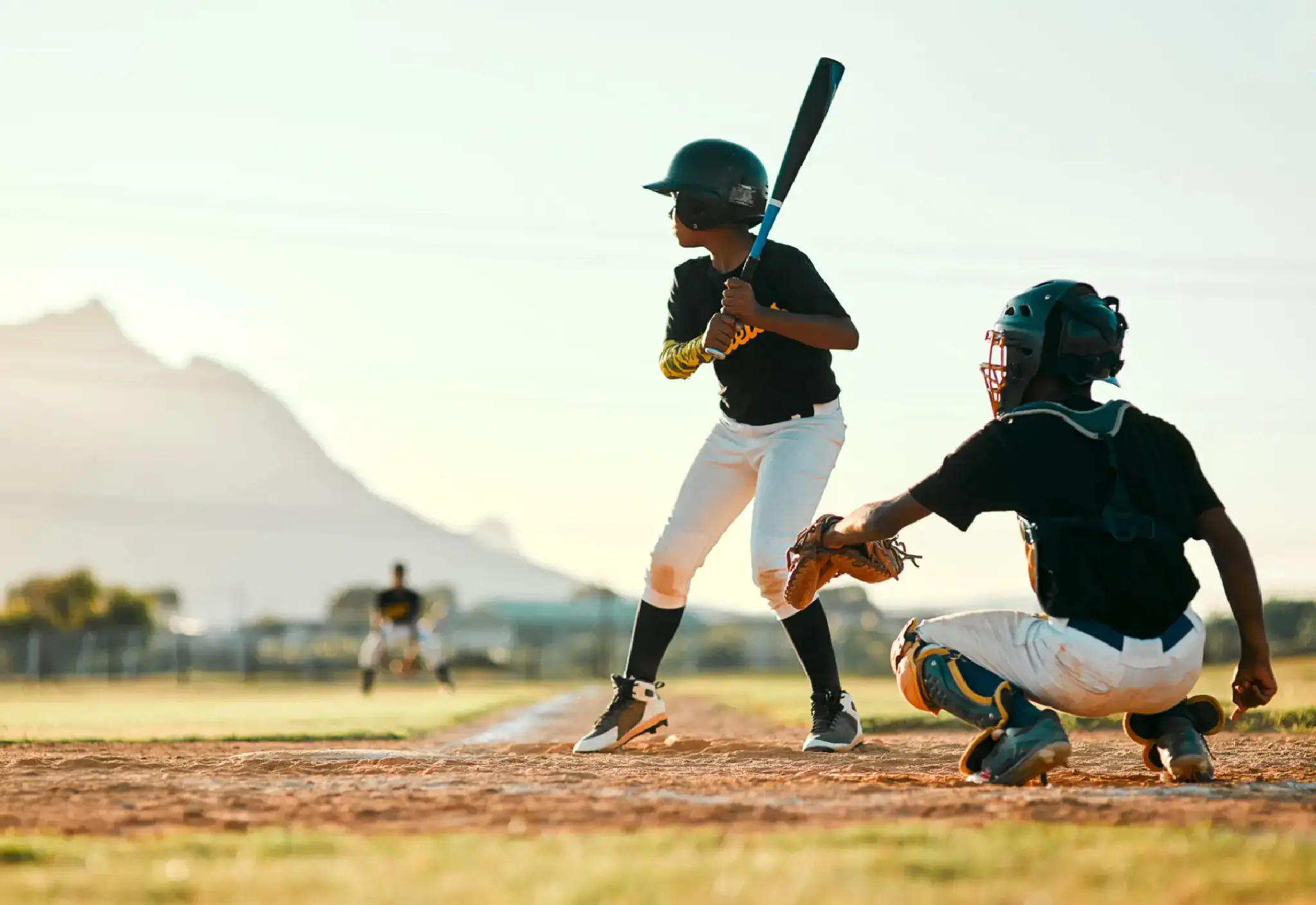 Youth baseball game with batter and catcher.