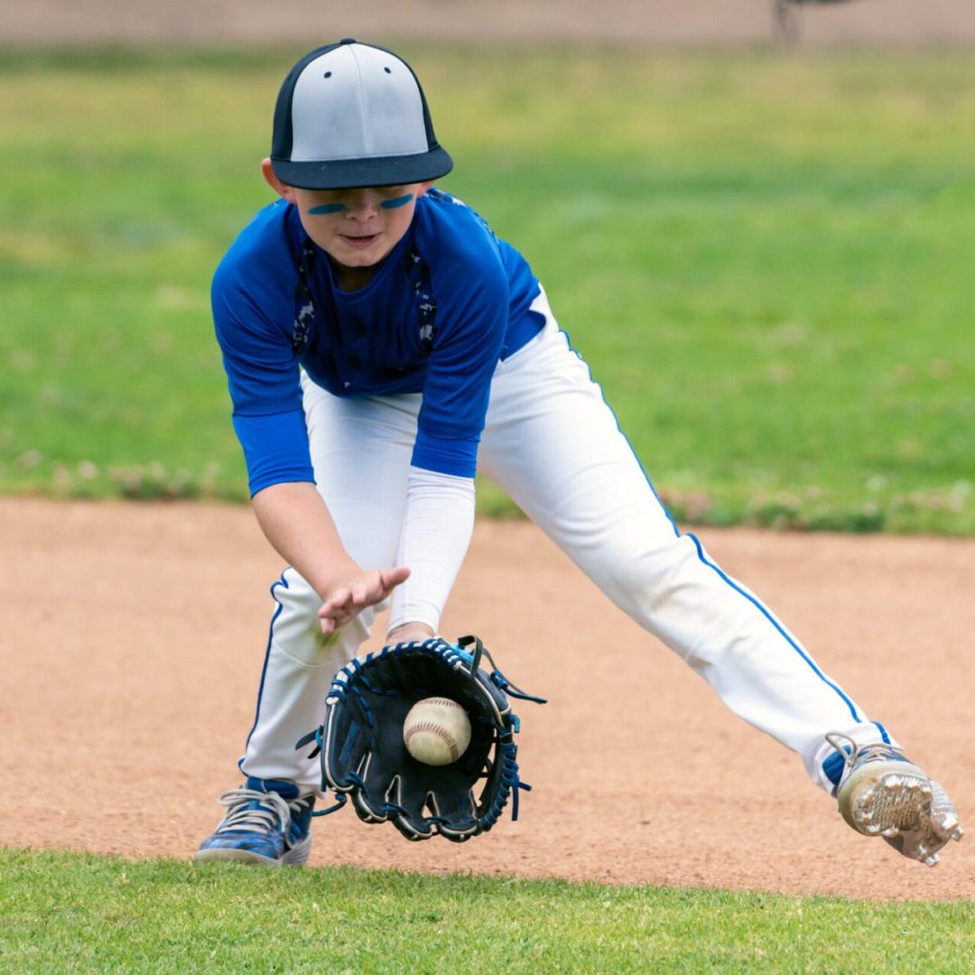 Young baseball player catching ground ball.